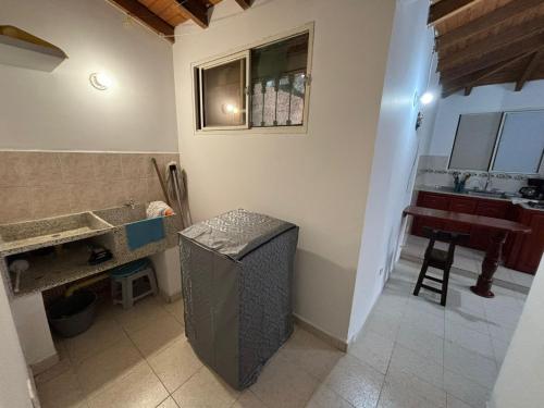 a bathroom with a sink and a counter with a stool at Apartamento barrio Simón Bolívar in Roldanillo