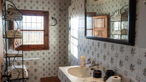 a bathroom with a sink and a mirror at Mas de Paco, Chimenea, barbacoa y piscina in Vall dʼAlba