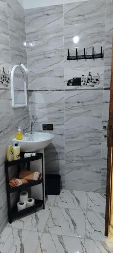 a bathroom with a sink and a marble wall at Dar Fatima in Aït Ali