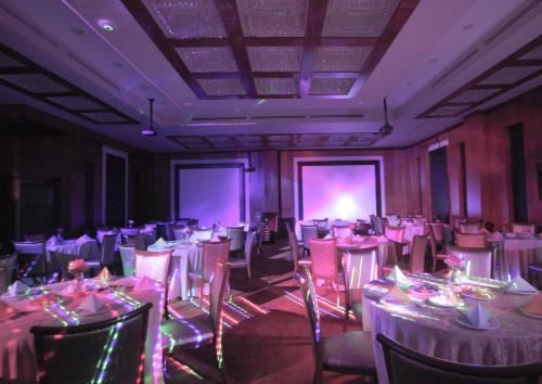 a room filled with tables and chairs with purple lighting at Marsa Diba Hotel in Ḑubā