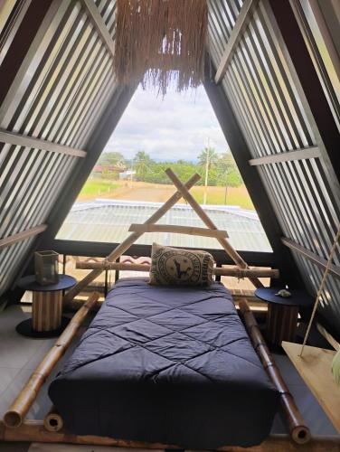 a bed in a room with a large window at A-frame cabin in Palma