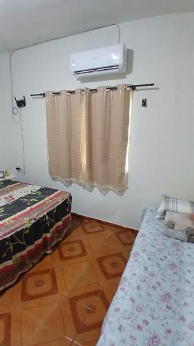 a bedroom with a bed and a window with curtains at Cantinho Amazônico in Belém