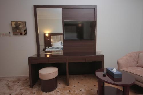 a room with a desk with a mirror and a bed at Marsa Diba Hotel in Ḑubā
