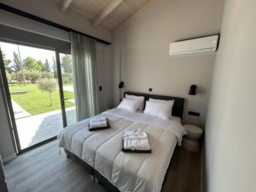 Olive Grove Villas Galaxidi في غالاكسيدي: غرفة نوم بها سرير عليه منشفتان