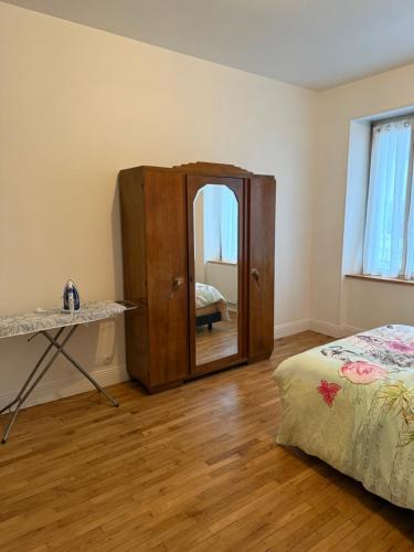 una camera da letto con uno specchio, una cassettiera e un letto di Namasté 1 a Étain