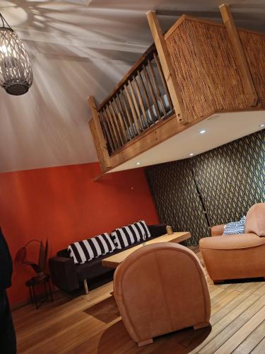 Petit loft cocoon في لي سابلِ دولونْ: غرفة معيشة بها كرسيان ودرج