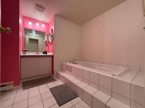 a large bathroom with a tub and a mirror at Comfy 2BR Pierrefonds Apt with included parking in Montréal