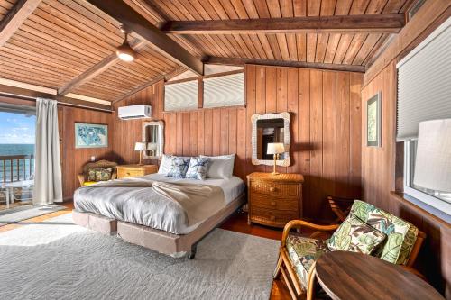 una camera da letto con un letto, un tavolo e una televisione di Beach Front Escape with Private Deck & Beach Access, Pet Friendly a Manasota Beach