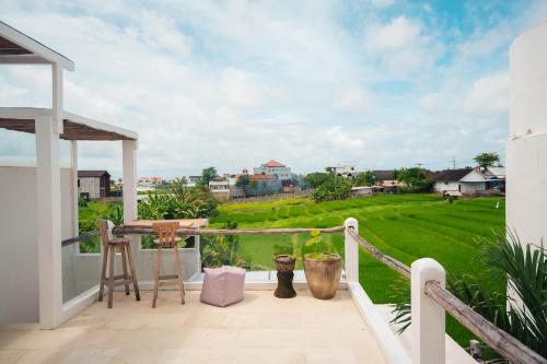 einen Balkon mit Blick auf ein grünes Feld in der Unterkunft Senyum Villa in Canggu