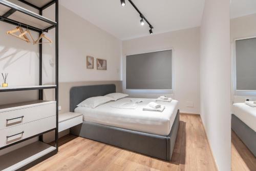 ティラナにある2BR at Artist's Palace - Skanderbeg Square Viewsのベッドと鏡のある白い寝室