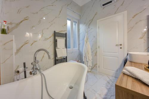 a bathroom with a tub and a sink at Aparatman Residence in Rijeka