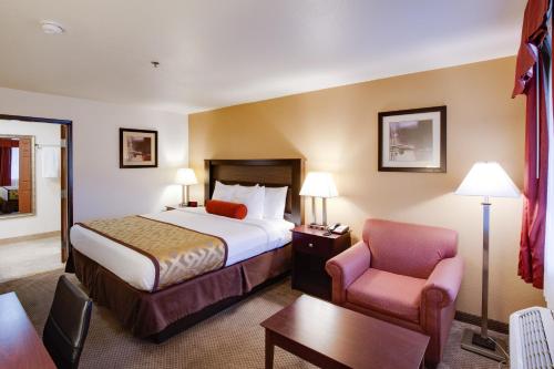 ein Hotelzimmer mit einem Bett und einem Stuhl in der Unterkunft Best Western Copper Hills Inn in Globe