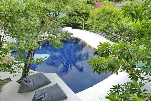 - une vue sur la piscine bordée d'arbres dans l'établissement v15 Ocean Serenity Residence, à Ko Pha Ngan