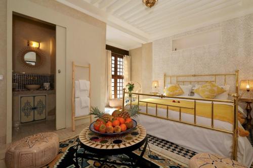 a bedroom with a bed and a bowl of fruit on a table at Riad Beata - Private use option - in Marrakech