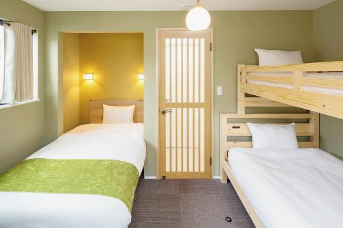 two beds in a room with two bunk beds at HANA HOUSE Tokyo - Family House near Haneda Airport in Tokyo