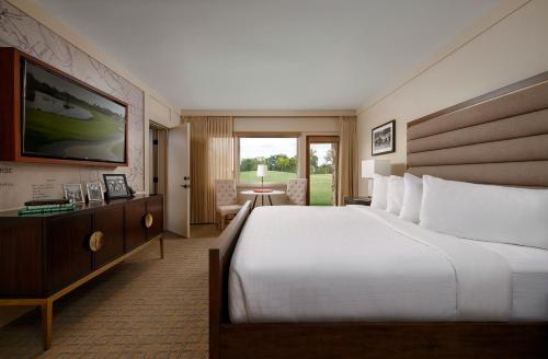 Una habitación de hotel con una cama grande y un televisor. en Arnold Palmer's Bay Hill Club & Lodge, en Orlando