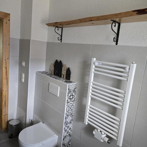 a white bathroom with a toilet and a shelf at NEU! Ferienwohnung HappyNest in Sondershausen