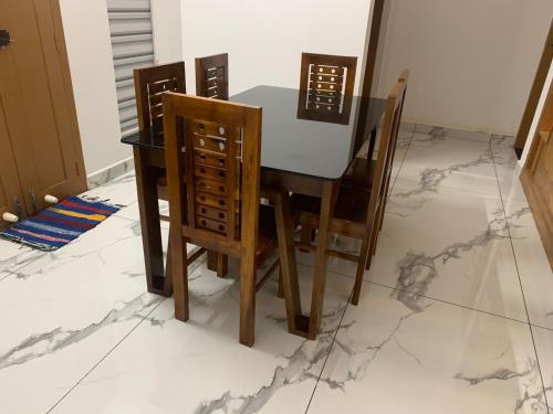 a dining room table and chairs on a marble floor at The white luxury Homestay in Thekkady