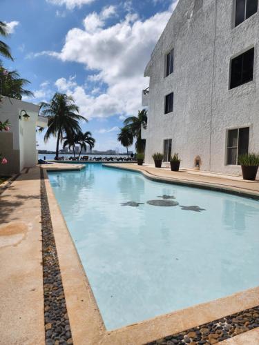 a large swimming pool next to a building at Apartment with a lagoon view in Cancún