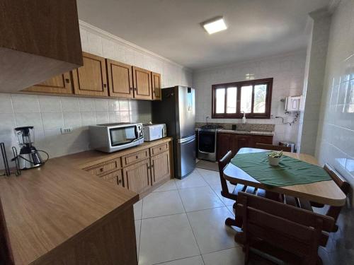 Apto 101 Edifício Manoel Teixeira في أرويو دو سيلفا: مطبخ مع طاولة وثلاجة
