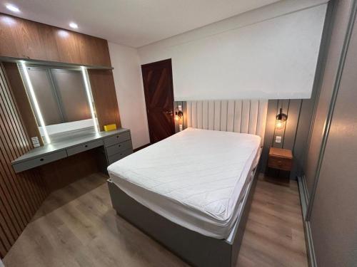 Apto 101 Edifício Manoel Teixeira في أرويو دو سيلفا: غرفة نوم صغيرة بها سرير ومكتب