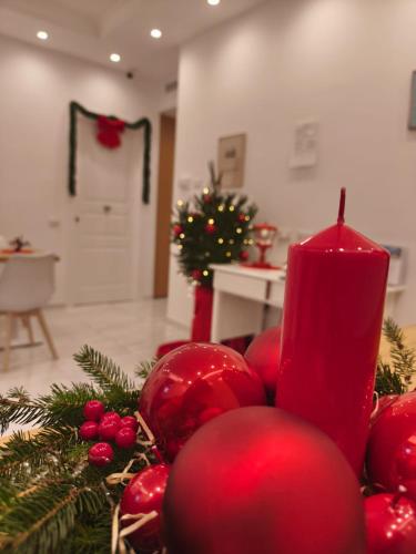 Uma vela vermelha sobre uma mesa com decorações de Natal. em Relais San Francesco em Sorrento