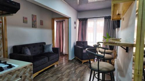 Casa Aluna في Ríoverde: غرفة معيشة مع أريكة وكراسي ومطبخ