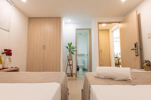 a hotel room with two beds and a bathroom at Casa Mishka Hotel Boutique Habitación #104 Nuevo Cartagena in Cartagena de Indias