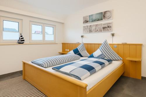 a bedroom with a bed with blue and white pillows at Fewo Mainau in Unteruhldingen