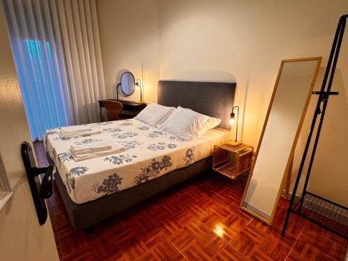 a small bedroom with a bed and a mirror at Casa da Maria Reguila in Porto