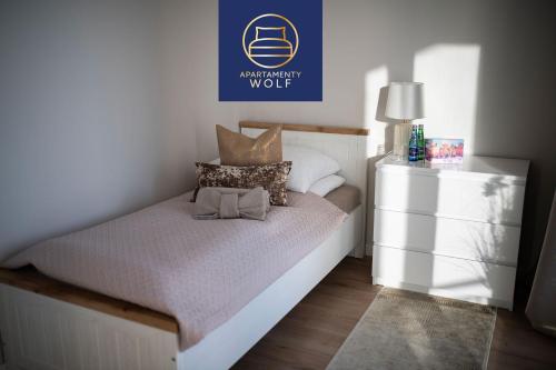a small bedroom with a bed and a white dresser at Apartament Kaszmirowy in Grudziądz