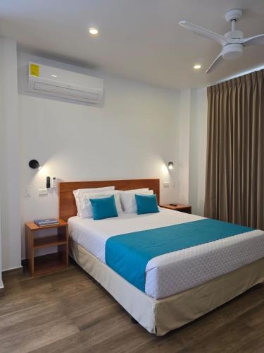 a bedroom with a large bed with blue pillows at Casa Galapagos in Puerto Ayora