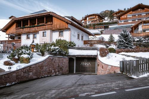 a house with a garage in the snow at Anna Lodges Dolomites in Santa Cristina in Val Gardena