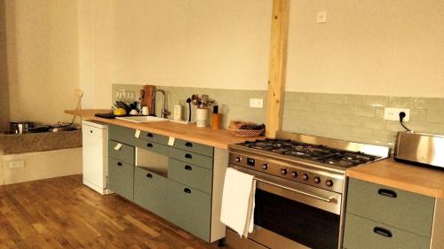 een keuken met een fornuis en een aanrechtblad bij A la belle étoile - Auberge in Mellionnec