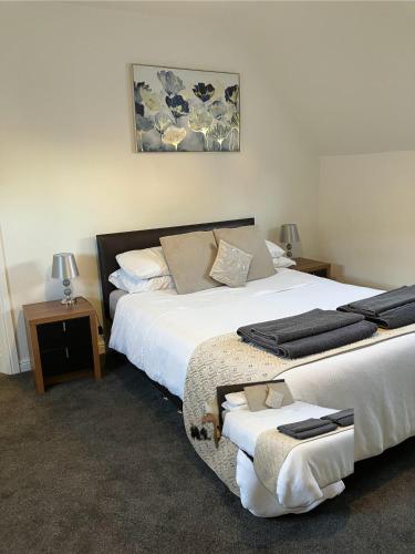 a bedroom with two beds with towels on them at The White Hart Hotel in Shefford