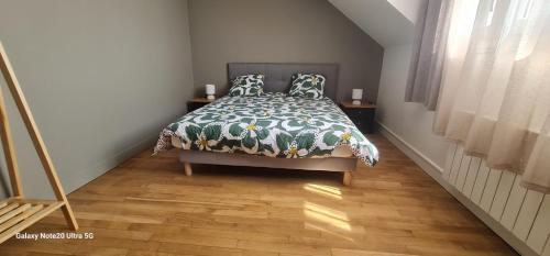 - une chambre avec un lit et une couette verte et blanche dans l'établissement Belle appartement, à Monéteau