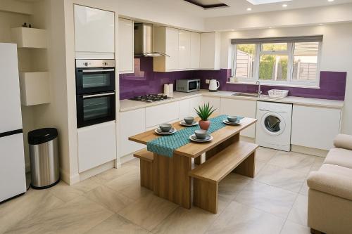 a kitchen with a wooden table in a kitchen at Spacious Modern 5 bedroom home near Heathrow Windsor in Canvey
