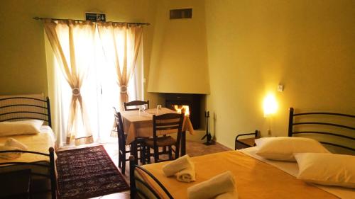 a room with two beds and a table and a dining room at Guesthouse Eleftherios in Kalavrita