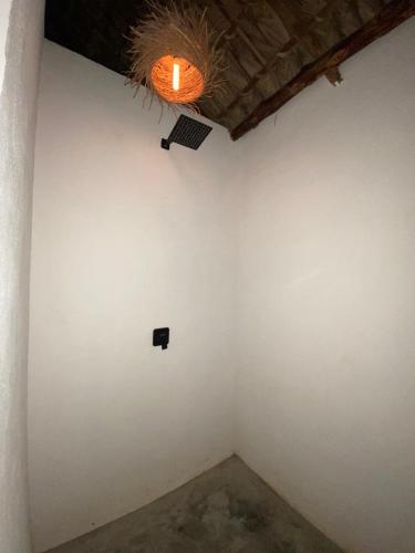 a room with a white wall and a light at Cabañas y Restaurante La Luna in Boca del cielo
