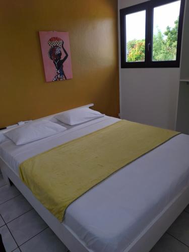 ein großes Bett in einem Zimmer mit Fenster in der Unterkunft Gwada Vakans in Saint-François