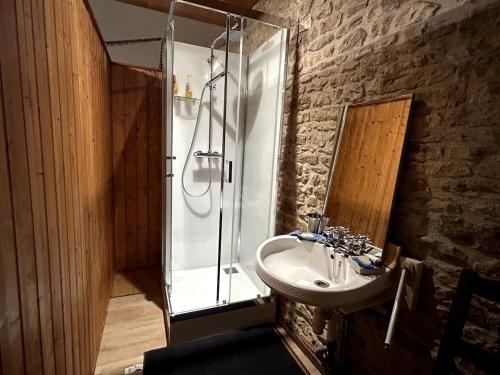 un bagno con lavandino e doccia in vetro di Maison de campagne a Nanteuil-en-Vallée