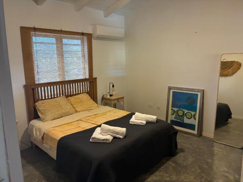 a bedroom with a bed with two towels on it at villa suiker tuintje in Kralendijk