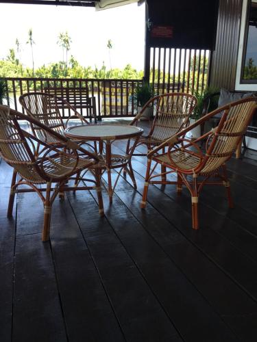 a group of chairs and a table on a porch at Maena Water Chalets in Tumpat