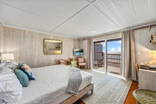 a bedroom with a large bed and a balcony at Gulf Front Escape on the Beach with Shared Lounging Deck & Pool in Englewood