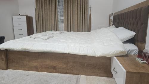 a bed with white sheets and pillows on it at شقة جميلة مطلة على الشاطيLuxury MUSCAT Apartment with Sea View in Ḩayl Āl ‘Umayr