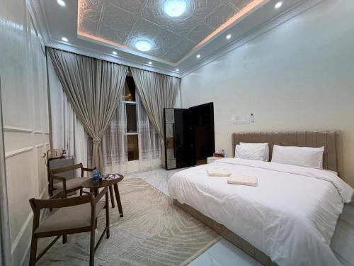 ein Schlafzimmer mit einem Bett, einem Tisch und einem Stuhl in der Unterkunft Arabian Sea Marina - مرسى بحر العرب in Sur