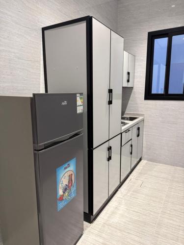 une cuisine avec un réfrigérateur avec une photo dessus dans l'établissement شقة Vip عائلية وصول ذاتي, à Hafr Al Baten