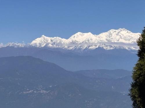een uitzicht op een met sneeuw bedekte berg met een meer bij P Square Resto Cafe n Stay in Darjeeling