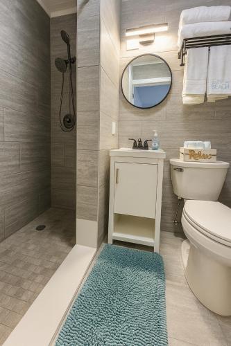 a bathroom with a toilet and a sink and a mirror at 1915 Beach Club in Daytona Beach