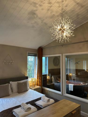 Un dormitorio con una cama y una lámpara de araña en Cupid Lodge, en Kingham